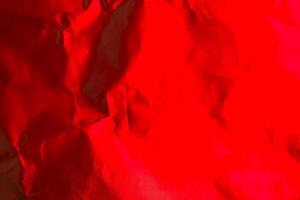 Bright red crumpled paper creates an artistic background for creative design or decoration purposes photo