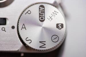 Camera settings dial showing various modes including manual, auto, and Wi Fi settings in a close up view photo