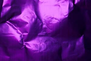Crumpled purple foil creating unique textures and patterns under soft light in a compact space photo