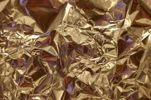 Shimmering golden foil with intricate textures creates a dynamic visual effect in a bright setting photo