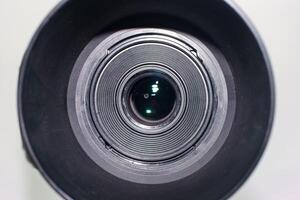Close view of a camera lens showcasing its intricate details and reflection in natural light photo