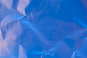 Crumpled blue paper texture showcasing shades of light and shadow in a vivid and abstract composition photo