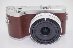 Compact camera with a stylish design featuring a brown leather grip and wide angle lens on a clean background photo