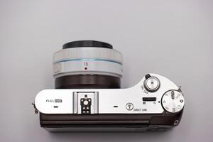 Camera with modern design showcasing control settings and lens details on a neutral background photo