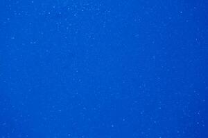 Deep blue background filled with shimmering particles creating a serene and tranquil atmosphere during sunset photo