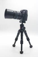 Perfectly positioned camera set up on a sturdy tripod against a clean white background for photography projects or studio work photo