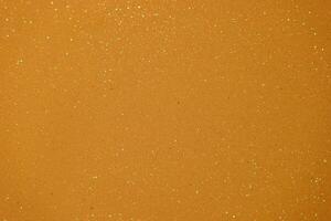 Sparkling golden surface with shimmering particles captured under bright light in a creative setting photo
