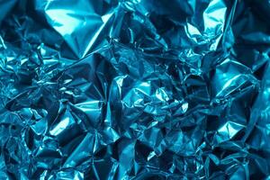 Vibrant blue metallic foil texture evokes depth and complexity in a close up view of crinkled aluminum photo