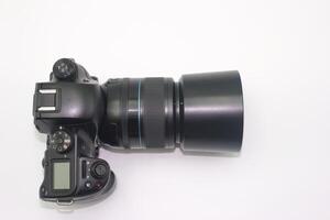 Digital camera with large lens displayed on a white background showcasing photography equipment details photo