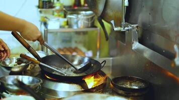 Chef skillfully cooks with a wok in kitchen video
