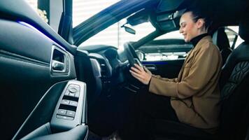 A satisfied, happy woman client sitting behind the wheel of a new car. Concept a joyful moment of car ownership, highlighting the excitement photo