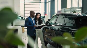 A car dealer advises a customer on the purchase or lease of a new car at a car dealership. The concept of an expensive purchase or lease of a modern car. photo