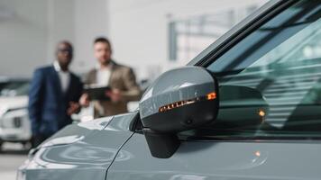 A car dealer in a modern car dealership advises an African-American customer on buying or leasing a new car. The concept of an expensive purchase or lease of a modern car. photo
