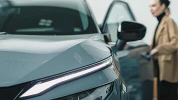 Car sales manager showing a car to a customer in a car showroom. Purchase concept and assistance photo