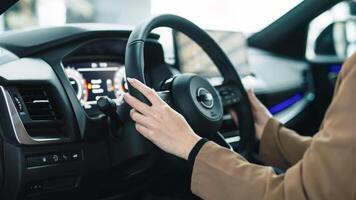 Business lady grips the steering wheel of a modern new car. Concept of choosing a new prestigious car. photo