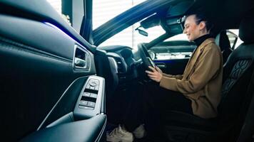 Business lady grips the steering wheel of a modern new car. Self-confidence and ambition are reflected in the choice of a new prestigious car. photo