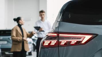 The concept of an expensive purchase or lease of a car. A car dealer advises a customer on the purchase or lease of a new car. photo
