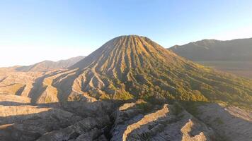 Cinematic aerial view of Mount Batok at golden sunrise near Mount Bromo. Rugged volcanic textures and warm morning light in East Java, Indonesia. video