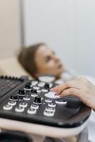 Concept medical imaging and diagnostic technology. Close-up of ultrasound machine as medical worker performs scan. photo