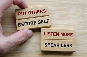 Put others before self message on wood cubes, highlighting a servant leadership mindset where empathy and humility come first photo