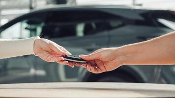 Closing the car purchase transaction with the delivery of the keys. The concept of the final stage of a flawless purchase, sale or test drive of a car, emphasizing the customer's satisfaction photo