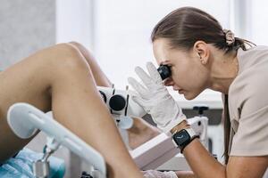 Close up of gynecologist using colposcope to examine cervix. Concept of women's health care photo