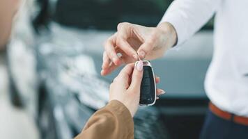 Closing the car purchase transaction with the delivery of the keys. The concept of the final stage of a flawless purchase, sale or test drive of a car, emphasizing the customer's satisfaction. photo