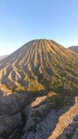 Cinematic aerial view of Mount Batok at golden sunrise near Mount Bromo. Rugged volcanic textures and warm morning light in East Java, Indonesia. video