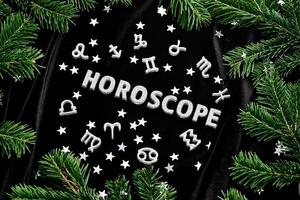 Abstract New Year background with the inscription Horoscope on a black velvet background. photo