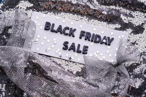 BLACK FRIDAY SALE sign on a sparkling silver sequin background. photo