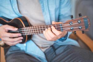 He strums a reggae rhythm on his four-string instrument. photo