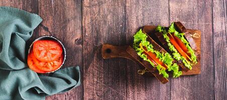 Light sandwich with vegetables and cheese on rye bread on a board top view web banner photo
