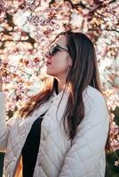 Woman enjoying spring blossoms in a sunny park during late afternoon photo