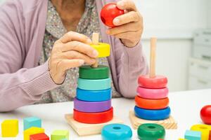 elderly woman patient suffering from dementia learn practical motor skills rehabilitation. photo