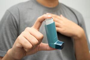 Asthma chronic obstructive pulmonary disease COPD, Asian young man using metered dose photo
