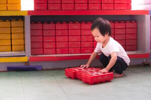 Cute boy playing with buiding toy colorful blocks with happy face. Plastic Large Toy. Preschool activities and early childhood education. Asian child aged 2 years old. photo