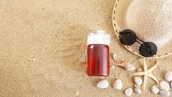 Top view flat lay of summer hat, sunglasses, a drink tumbler, and ocean animals isolated on beach sand background photo