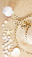 Top view flat lay of summer holiday concept with summer hat, a drink tumbler, and sea creatures isolated on beach sand background photo