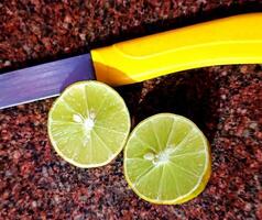 Fresh Lemon Cut in Half with Knife on Kitchen Countertop photo