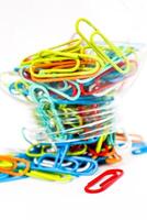 Vibrant Multi-Colored Paper Clips Overflowing from a Container on a White Background photo