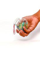 Paper Clips in a Jar Held by a Hand on White Backdrop - Isolated Object photo
