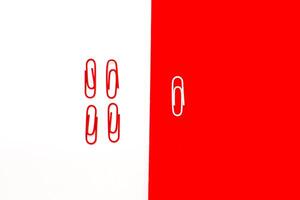 Minimalist composition of red and white paper clips on contrasting backgrounds photo