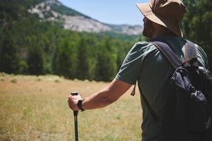 Bearded Man Exploring Nature with Backpack on a Sunny Summer Day photo