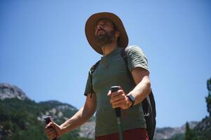 Bearded Male Hiker with Hat Exploring Nature During a Sunny Day photo