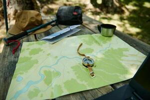 Comprehensive Camping Setup on Wooden Table with Map and Compass photo