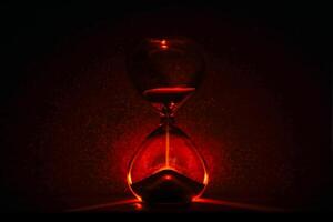 artistic glowing hourglass like sunrise or sunset, symbolizing time and creativity. Vibrant lighting against a dark minimalist backdrop. Concepts of time management, life balance, and artistic design. photo