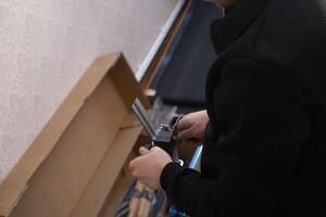 Man repairs and assembles furniture by himself showing professional approach and attention to detail at home. photo