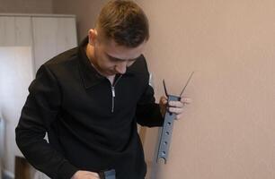 Man carefully assembling furniture parts creating a strong and reliable interior for a comfortable living space. photo