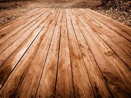 Weathered wooden planks laid out on a ground covered with dry leaves Texture photo