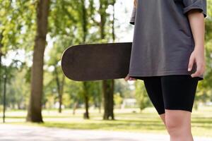 Anonymized view of a skateboarder with their gear in a serene park backdrop, offering a clean, customizable scene for adding text or graphic elements photo